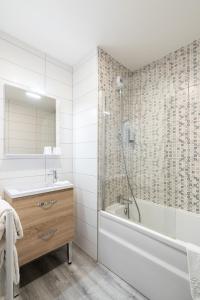y baño con bañera, lavamanos y ducha. en Hotel Restaurant Le Sainte Mere, en Sainte-Mère-Église