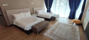 a hotel room with two beds and a couch at Lodge 16 Private Villa in Kuah