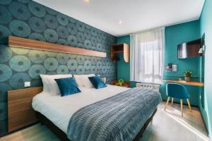 a bedroom with a large bed with blue walls at Hotel Restaurant Le Sainte Mere in Sainte-Mère-Église