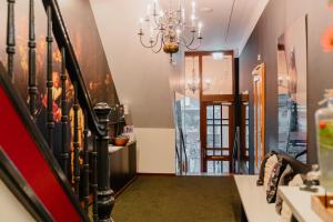 um corredor com uma escada e um lustre em Hotel Fita em Amsterdã