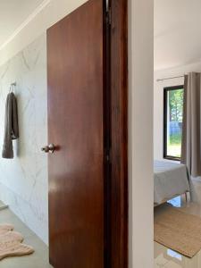 a wooden door in a room with a bedroom at CASA moderna en la floresta a 5 minutos de Punta Ballena in Maldonado