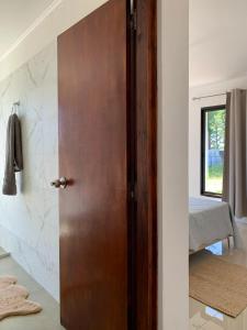 Una puerta de madera en una habitación con 1 dormitorio en CASA moderna en la floresta a 5 minutos de Punta Ballena, en Maldonado