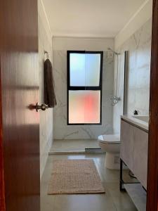 a bathroom with a toilet and a window at CASA moderna en la floresta a 5 minutos de Punta Ballena in Maldonado