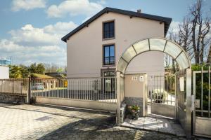 a house with an archway in front of a fence at Lucy’s House in Cologno Monzese