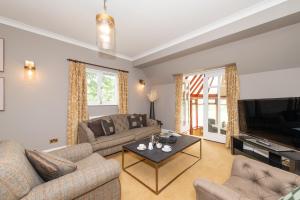 a living room with a couch and a tv at Appleby Manor Hotel & Garden Spa in Appleby