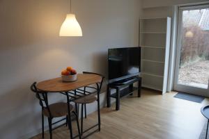 uma sala de estar com uma pequena mesa e uma televisão em (id110) Grønlandsparken 56. G em Esbjerg