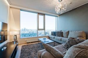 a living room with a couch and a large window at Luxurious, Skyline View Apartment near Centre in Tallinn