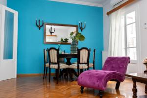 a dining room with a table and purple chairs at Aggire Zante Retro Residence in Zakynthos