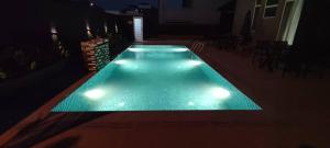 a swimming pool with lights in a dark room at Lodge 16 Private Villa in Kuah