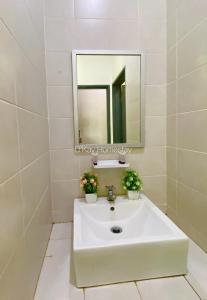 a bathroom with a white sink and a mirror at Mesahill 2 Bedroom by DKAY in Nilai in Nilai