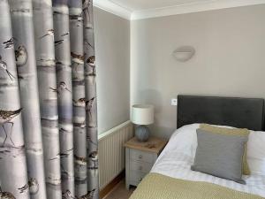 un dormitorio con una cama y una cortina con pájaros. en Crabshell Quay waterfront living in Kingsbridge, en Kingsbridge