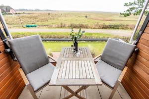 uma mesa e duas cadeiras num alpendre com vista para um campo em Heefwai 2 W6 em Morsum