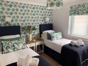 1 dormitorio con 2 camas y toallas. en Crabshell Quay waterfront living in Kingsbridge, en Kingsbridge