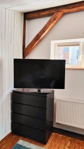 a flat screen tv sitting on top of a black dresser at Seeyouin Karmelicka18 Apartment in Krakow