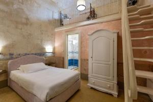 a small bedroom with a bed and a staircase at Dimore Briganti Gallipoli Centro in Gallipoli