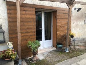 Una entrada de madera a una casa con puerta en Bienvenue « À l’ombre du figuier » en Pieusse