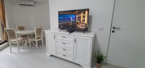 uma cómoda branca com uma televisão por cima em Solid Residence Lake Boutique Apartment 11 em Mamaia