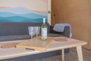 a bottle of wine and two glasses on a coffee table at Loch Aline Pod in Pennyghael