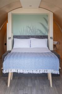 a large bed in a room with a large headboard at Loch Aline Pod in Pennyghael