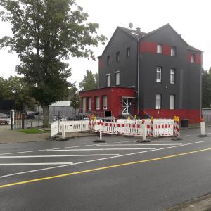 een groot gebouw met een wit hek naast een straat bij Delta Haus in Gelsenkirchen