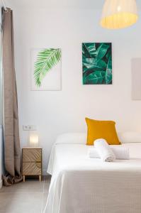 um quarto branco com 2 camas e uma luz pendente em YourHouse Monges apartment with balcony em Can Picafort