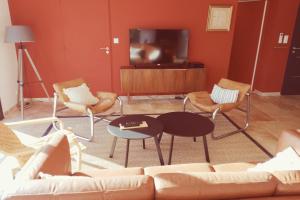 ein Wohnzimmer mit einem Sofa, Stühlen und einem TV in der Unterkunft House With Piscine At The Gates Of Avignon in LʼIsle-sur-la-Sorgue