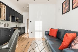 a living room with a couch and a kitchen at Modern Apartment, 2 Stops to Central London, Netflix, Smart Locks in Ealing