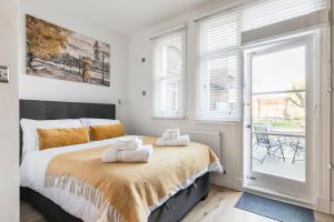 1 dormitorio con 1 cama con toallas en Modern Apartment, 2 Stops to Central London, Netflix, Smart Locks, en Ealing