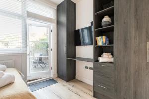 a bedroom with a book shelf and a window at Modern Apartment, 2 Stops to Central London, Netflix, Smart Locks in Ealing