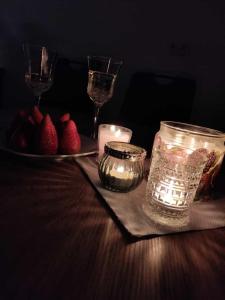 a table with candles and a plate of strawberries and wine glasses at Romantiksuite bei Seitberger in Frauenberg