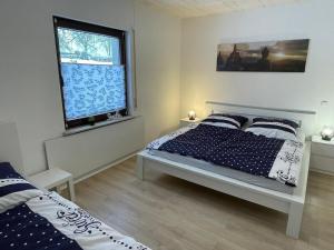 Schlafzimmer mit einem Bett und einem Fenster in der Unterkunft Ferienhaus Lichtenberg - b46149 in Herleshausen