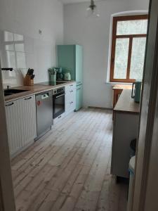 eine Küche mit Holzboden in einem Zimmer in der Unterkunft Ferienwohnung mit Blick auf die Elbe und den Lilienstein in Königstein an der Elbe