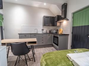 a kitchen with a desk and a table in a room at Cosy retreat Pass the Keys in Beeston