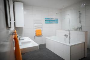 a white bathroom with a tub and a sink at Premium Apartments Monterra in Petschnitzen