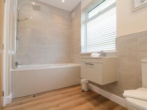 une salle de bain avec une baignoire, une douche et un lavabo dans l'établissement Seapoint, à Filey 42 autres photos
