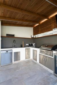 a large kitchen with stainless steel appliances and wooden ceilings at Casa Reina Helena - welcome to a special place in Busot