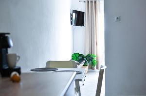 a white dining room with a table and chairs at Daphne's studio 1 in Skiathos