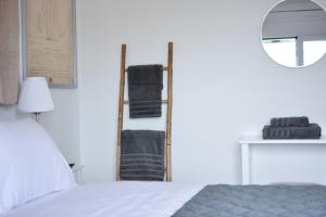 ein weißes Schlafzimmer mit einem Bett und einem Spiegel in der Unterkunft Daphne's studio 1 in Skiathos-Stadt
