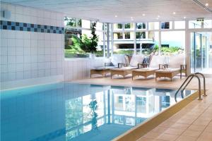 ein Swimmingpool mit Stühlen und einem Tisch in der Unterkunft Ostseepark Karavelle 37 in Heringsdorf