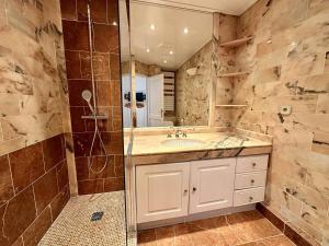 ein Bad mit einem Waschbecken und einer Dusche in der Unterkunft Cannes Croisette - Appartement 5 pièces face mer in Cannes