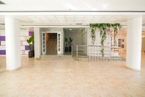 a lobby with white columns and plants at htop Amatista #htopBliss in Lloret de Mar