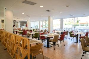 a restaurant with tables and chairs and a person in the background at htop Amatista #htopBliss in Lloret de Mar