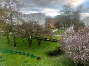 a park with trees and a building in the background at Olo Apartment in Warsaw