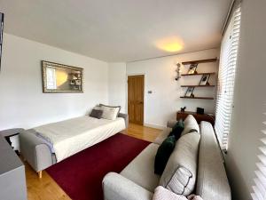 a living room with a couch and a bed at Colindale Lush Stay 30 mins central London in Colindale