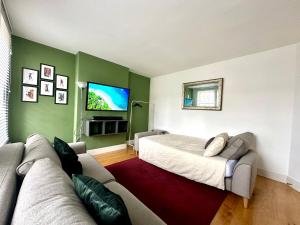 a living room with a bed and a couch at Colindale Lush Stay 30 mins central London in Colindale