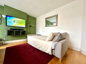 a bedroom with a bed and a tv on the wall at Colindale Lush Stay 30 mins central London in Colindale