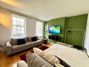 a living room with a couch and a tv at Colindale Lush Stay 30 mins central London in Colindale