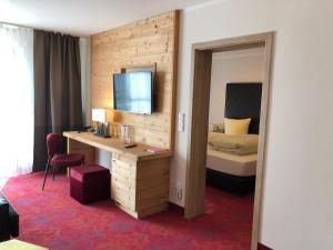 a hotel room with a bed and a desk and a mirror at Hotel Wurzer in Tännesberg