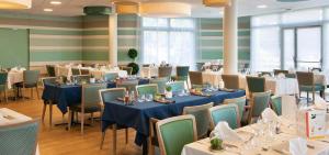 une salle à manger avec des tables, des chaises et un chiffon bleu dans l'établissement DOMITYS L'AIGRETTE BLEUE, à Abbeville