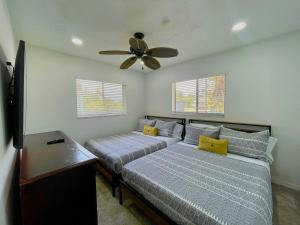 1 Schlafzimmer mit 2 Betten und einem Deckenventilator in der Unterkunft Fort Myers Beach Escape 3 Miles Away Sleep 7 in Fort Myers Beach